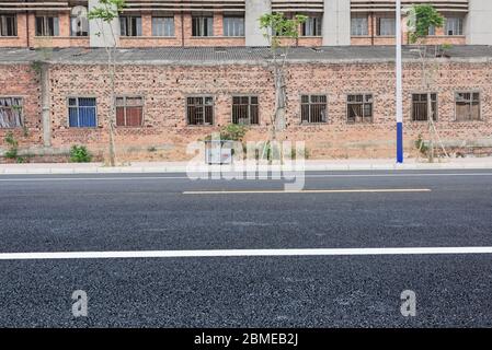 Strada asfaltata dritta all'aperto in vecchia area industriale. Foto Stock