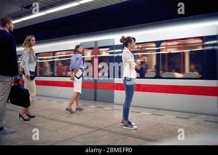 Uomini d'affari che aspettano la metropolitana in subway.Young persone che aspettano un treno in metropolitana. Foto Stock