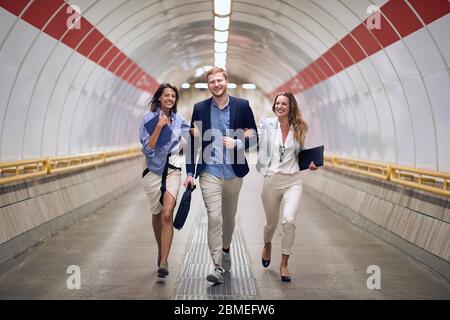 Persone di successo in viaggio d'affari nella stazione della metropolitana.giovani persone a piedi alla piattaforma alla stazione ferroviaria.Urban stile di vita e concetti di trasporto. Foto Stock