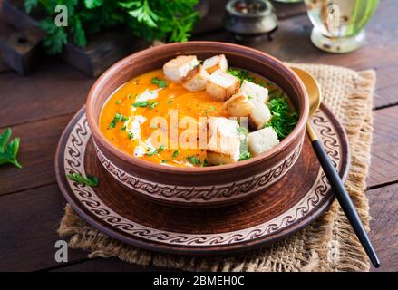 Zuppa di zucca in una ciotola servita con crostini e prezzemolo. Zuppa di dieta vegana. Cibo vegetariano. Foto Stock