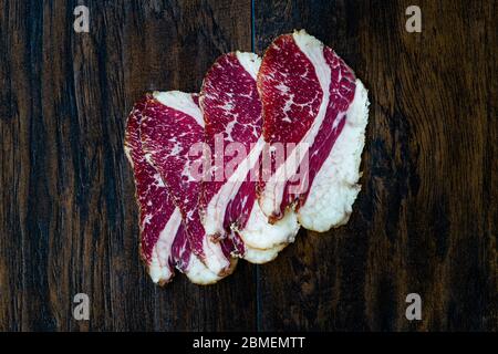Fette di costolette di vitello invecchiate e non gregge affumicate. Sottile a fette e taglio Prato / Salame. Pronto a mangiare. Foto Stock