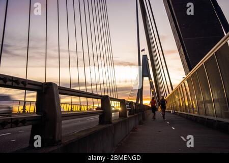 Auto e joggers che arrivano sul ponte Anzac al crepuscolo a Sydney Foto Stock