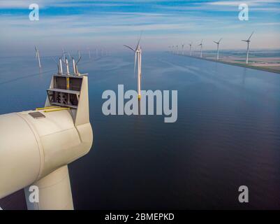 Vista ravvicinata con drone al parco dei mulini a vento nel lago Ijsselmeer nei paesi bassi Noordoostpolder, turbine a vento dall'alto in Europa che produce Foto Stock
