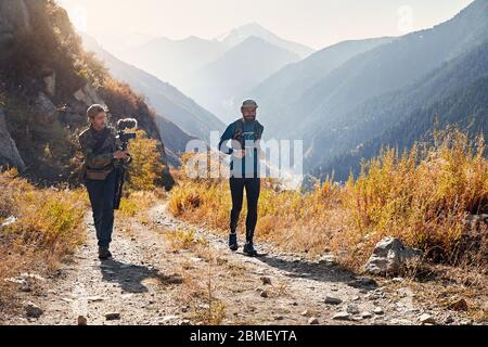 Regista di documentari di scatto su runner atleta sul sentiero selvaggio della montagna Foto Stock