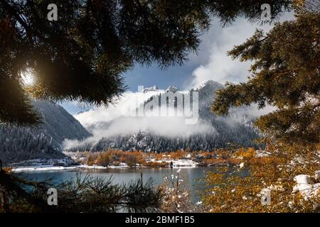 Bella vista della montagna lago Issyk con alberi di giallo in autunno a neve montagne sfondo in Kazakistan e in Asia centrale Foto Stock