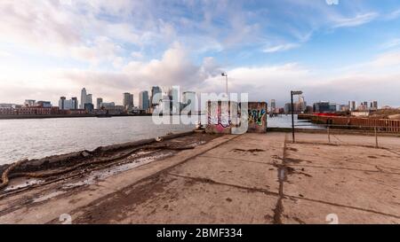 Londra, Inghilterra, Regno Unito - 27 gennaio 2013: Il Tamigi scorre tra i grattacieli di Canary Wharf e i terreni industriali di derelict nel NOR Foto Stock
