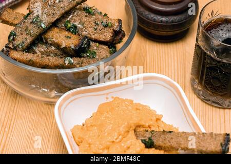 Spuntino alla birra crostini fritti con salsa al formaggio su tavola di legno. Crostini di pane di segale con aglio, olio e sale. Bevande e cibo. Foto Stock