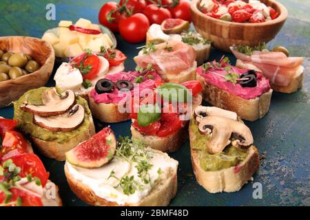 Bruschette assortite con vari condimenti. Bruschetta appetitosa o crostini crudo. Varietà di piccoli panini. Mescolare la bruschetta Foto Stock