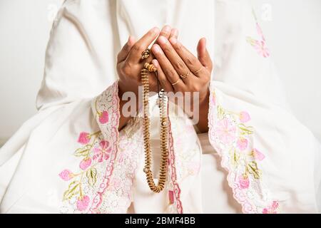 Donna musulmana che prega da vicino immagine delle mani come lei tiene perline di preghiera, tasbih - religioso, Islam, immagine concettuale con spazio di copia per il testo Foto Stock