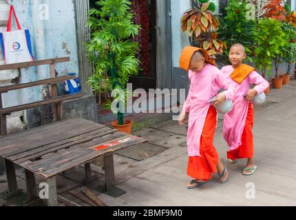 Yangon Myanmar - Ottobre 26 2013; viaggio e la gente immagini due ragazzi monaco novizio a piedi sulla strada della città con le loro ciotole elemosina. Foto Stock