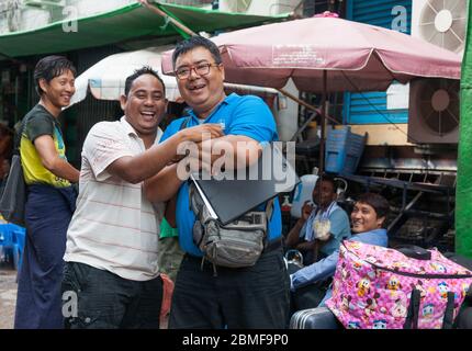 Yangon Myanmar - Ottobre 26 2013; due uomini d'affari birmani felici ridono per la macchina fotografica in strada caotico. Foto Stock