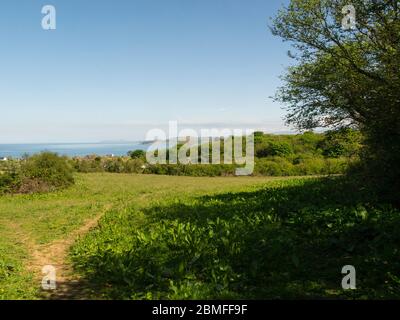 Vista attraverso Bennlech Bay verso Llanddona e la Grande Orme Llandudno da sopra l'Isola di Bennlech di Anglesey Galles del Nord Regno Unito Foto Stock