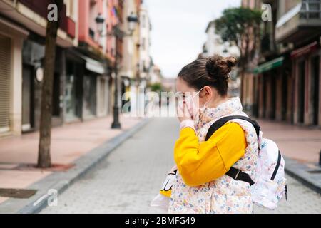 Una ragazza con una maschera sul suo volto nella strada di una città Foto Stock