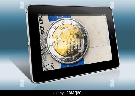 Moneta da 2 euro dell'Estonia sulle banconote in euro, vista su Tablet PC Foto Stock