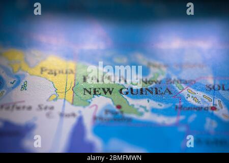 Profondità di campo poco profonda fuoco sulla mappa geografica posizione del paese Papua Nuova Guinea in Asia Oceania continente su atlas Foto Stock