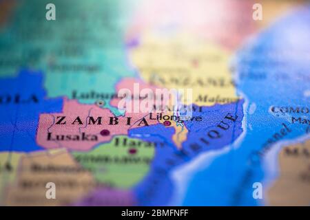 Profondità di campo poco profonda focalizzazione sulla mappa geografica posizione del paese Zambia nel continente africano sull'atlante Foto Stock