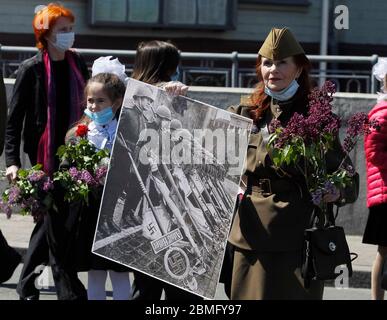 Kiev, Ucraina. 9 maggio 2020. Gli ucraini portano i fiori alla Tomba del Milite Ignoto durante la celebrazione della Giornata della Vittoria a Kiev, Ucraina, il 9 maggio 2020. Gli ucraini segnano il 75° anniversario della vittoria sulla Germania nazista nella seconda guerra mondiale, nel corso dell'epidemia di coronavirus COVID-19 in Ucraina. Credit: Serg Glovny/ZUMA Wire/Alamy Live News Foto Stock