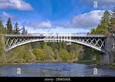 CARRON MORAY SCOZIA LA STRADA E LA FERROVIA PONTE SUL FIUME SPEY CON UNA MACCHINA ROSSA Foto Stock