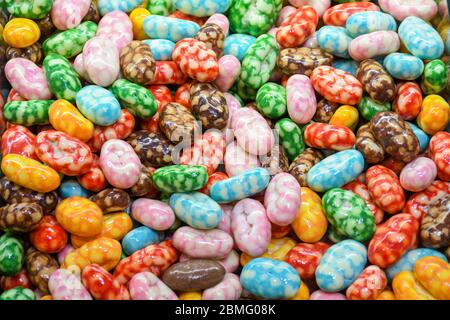 Draghi variopinti e multicolori, gocce di noci ricoperte di cioccolato, salsa di frutta, caramelle colorate, ceci arrosto al cioccolato. Foto Stock