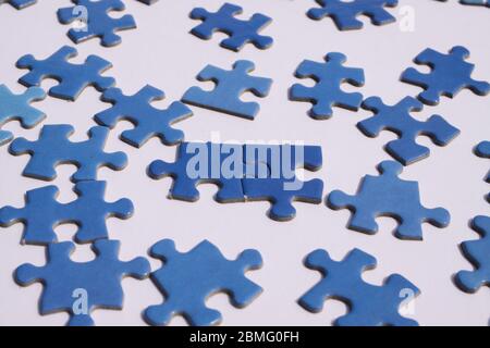 Primo piano di pezzi isolati puzzle blu, sfondo bianco Foto Stock