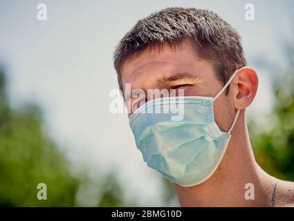 Uomo che indossa una maschera medica protettiva durante il blocco del coronavirus Foto Stock