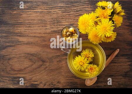 Tazza ph sano tè dente di leone su vintage sfondo di legno. Erbe fresche. Foto Stock