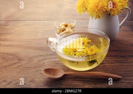 Tazza ph sano tè dente di leone su vintage sfondo di legno. Erbe fresche. Foto Stock