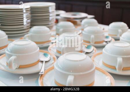 Gruppo di bicchieri in ceramica e piatti impilati sul tavolo per il servizio tè o caffè Foto Stock