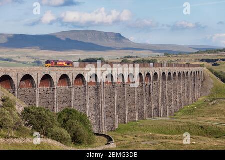 DB Cargo EWS livrea classe 66 locomotiva 66137 attraversamento del viadotto Ribblehead sul punto di partenza per la ferrovia Carlisle con un treno merci che trasporta gesso Foto Stock