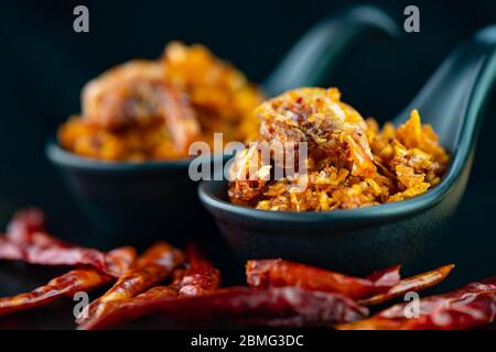 Pasta piccante piccante di gamberi in peperoncino nero su sfondo scuro Foto Stock