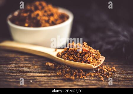 Pasta di peperoncino piccante e secca con cucchiaio di legno e fondo Foto Stock