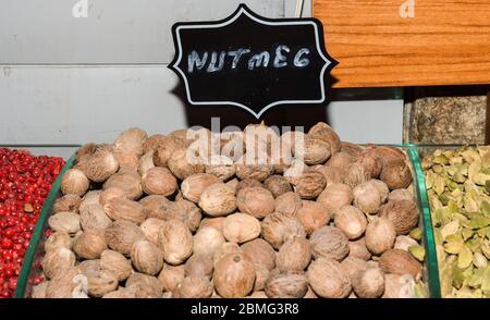 Mucchio di noce moscata piena asciutta sul mercato aperto. Macis fresco e noce moscata con fuoco selettivo Foto Stock