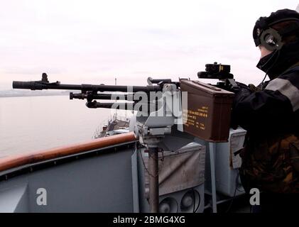 AJAXNETPHOTO. 29 FEB 2012. LIVERPOOL, INGHILTERRA. - HMS LIVERPOOL. GLASGOW TO LIVERPOOL PASSAGE - SAILOR MANS UNA DELLE MITRAGLIATRICI DA 7,62 MM PER USO GENERALE DELLA NAVE DA GUERRA MONTATA SULL'ALA DEL PONTE DI TIPO 45 CACCIATORPEDINIERE QUANDO ENTRA NEL FIUME MERSEY SULLA ROTTA VERSO IL TERMINAL DELLE NAVI DA CROCIERA. FOTO: JONATHAN EASTLAND/AJAX REF: GR122902 3338 Foto Stock