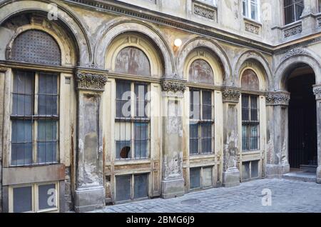 Un vecchio edificio a Budapest con le mura rustiche e l'antico arco. Foto Stock