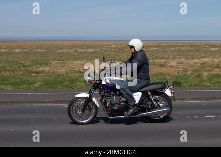 Triumph Bonneville T100; motociclista; trasporto a due ruote, moto, veicolo, strade, moto, motociclisti motociclisti che si trovano sulla strada costiera di Southport, Regno Unito Foto Stock