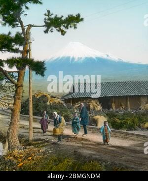 [ 1900 Giappone - Monte Fuji dal Tokaido ] - viaggiatori sul Tokaido, vicino al ponte Kawaibashi (河合橋) che attraversa il fiume Numakawa (沼川) vicino a Tagonoura (田子の浦), Fuji (富士市), Prefettura di Shizuoka. Sullo sfondo Mt. Fuji può essere visto. Testo originale: 'The view of Fujiyama from Kawaibashi, Yoshiwara.' vetrino vintage del xx secolo. Foto Stock