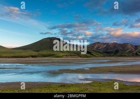 Fiume che scorre tra le montagne di rhyolite a Landmannalaugar Foto Stock