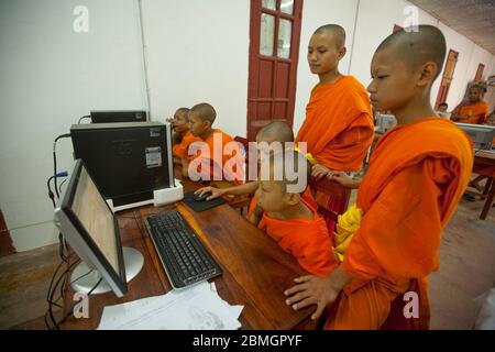 GIOVANI BUDDISTI MONACI CHE USANO COMPUTER A LUANG PRABANG, LAOS Foto Stock