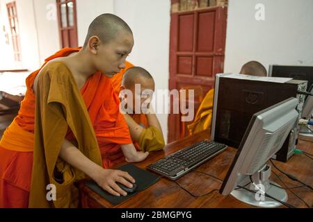 GIOVANI BUDDISTI MONACI CHE USANO COMPUTER A LUANG PRABANG, LAOS Foto Stock