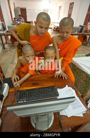 GIOVANI BUDDISTI MONACI CHE USANO COMPUTER A LUANG PRABANG, LAOS Foto Stock