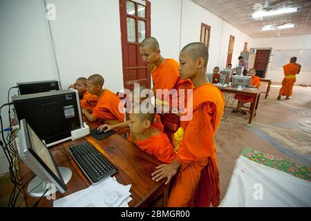 GIOVANI BUDDISTI MONACI CHE USANO COMPUTER A LUANG PRABANG, LAOS Foto Stock