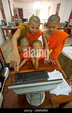 GIOVANI BUDDISTI MONACI CHE USANO COMPUTER A LUANG PRABANG, LAOS Foto Stock