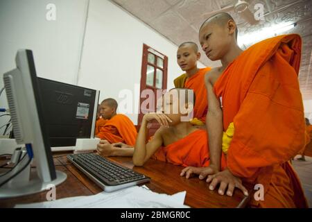 GIOVANI BUDDISTI MONACI CHE USANO COMPUTER A LUANG PRABANG, LAOS Foto Stock