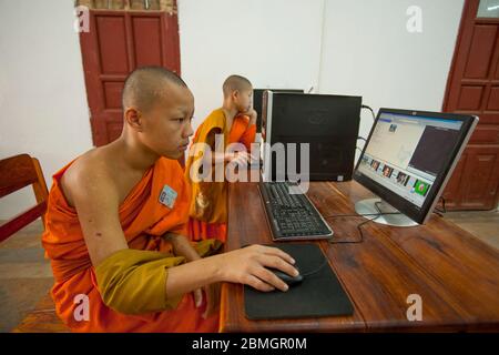 GIOVANI BUDDISTI MONACI CHE USANO COMPUTER A LUANG PRABANG, LAOS Foto Stock