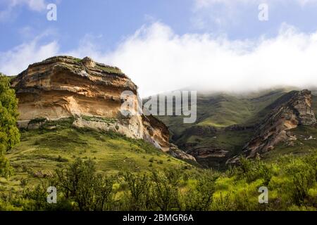 Scogliere di arenaria color arancio, nel praterie alpino austro-Afro ad alta quota del Drakensberg nel Golden Gate National Park, Sudafrica Foto Stock