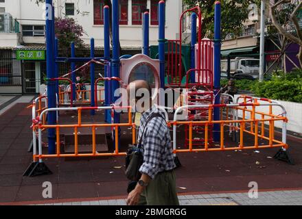 Hong Kong, Cina. 8 maggio 2020. Un uomo cammina davanti ad un parco giochi chiuso a Prince Edward, durante la pandemic del virus della corona.dopo settimane di basso numero di infezioni di Covid-19 nella città, bar, cinema e palestre si sono riaperti sotto guida sicura e limitata capacità. Credit: SOPA Images Limited/Alamy Live News Foto Stock