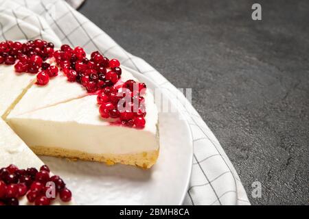 Piatto con delizioso cheesecake e frutti di bosco freschi sul tavolo Foto Stock