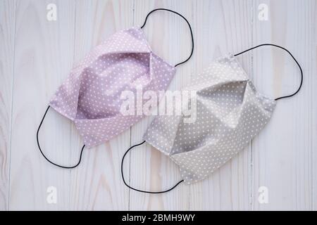 Due maschere mediche riutilizzabili realizzate a mano in tessuto. Prevenzione da coronavirus. Abbigliamento di protezione alla moda Foto Stock