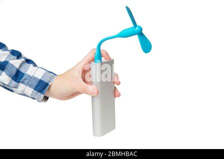 La mano femmina accende una ventola usb portatile collegata a un power bank color argento. Primo piano, isolato su bianco. Foto Stock