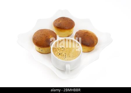 Cupcake fatti in casa e una tazza di caffè su una piastra quadrata bianca isolata su bianco. Concetto di pausa caffè. Foto Stock